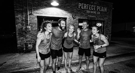 Friends laughing after a night run outside Perfect Plain Brewing Co.